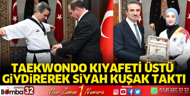 Taekwondo kıyafeti üstü giydirerek siyah kuşak taktı